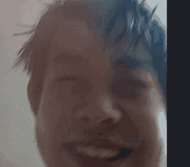 a close up of a man 's face with his eyes closed
