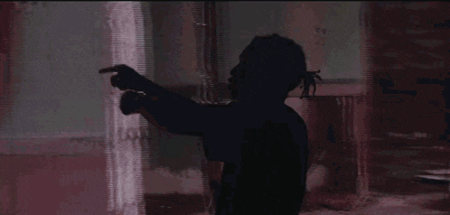 a silhouette of a person with their arms outstretched in front of a large screen