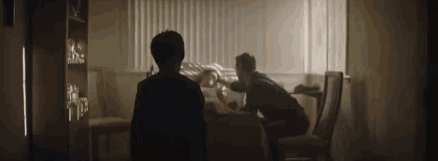 a man and woman are sitting at a table in a dark room .