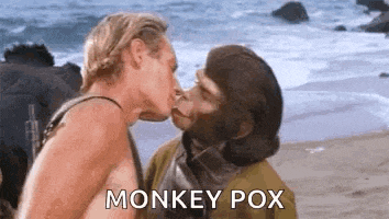 a man and a monkey kissing on a beach with the words `` monkey pox '' written on the bottom .
