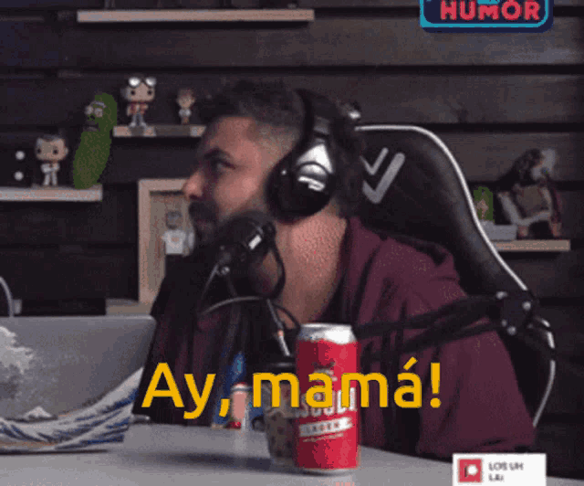 a man wearing headphones screams in front of a microphone and a sign that says humor
