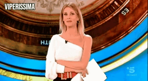 a woman in a white one shoulder top is standing in front of a sign that says " viperissima " on it