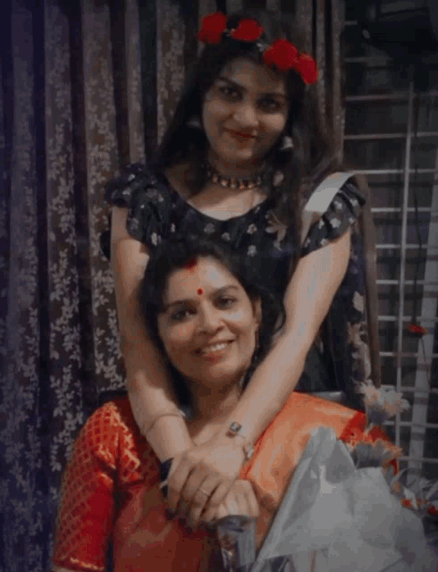 two women posing for a picture with one wearing a flower crown on her head