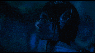 a close up of a person 's face in a dark blue background