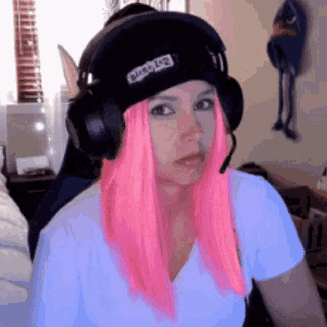 a woman with pink hair is wearing headphones and a black beanie that says bubble leg
