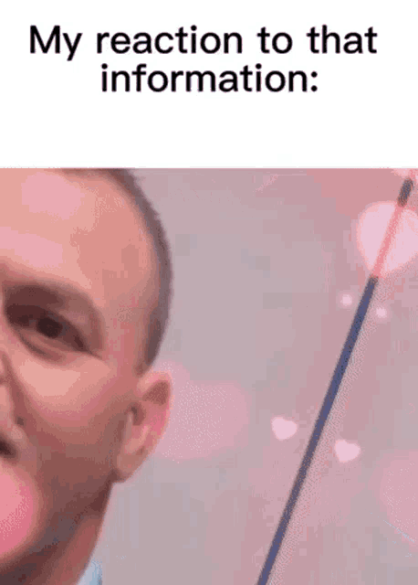 a man in a suit and tie is blowing a pink heart shaped bubble in his mouth .