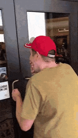 a man wearing a red hat is standing in front of a door that has a sign on it that says glendale one line