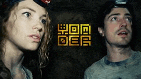 a man and a woman are looking up in a cave .