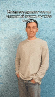 a man with his hands in his pockets stands in front of a patterned wall