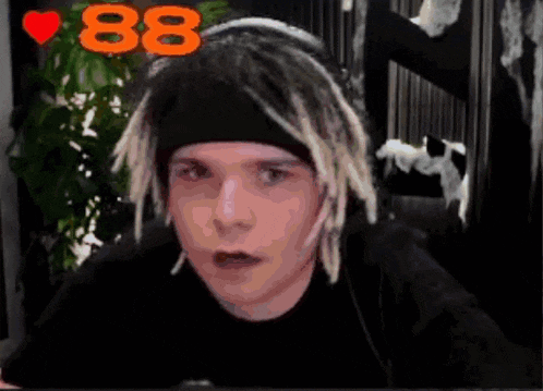 a man with dreadlocks wearing a headband with the number 88 on it .