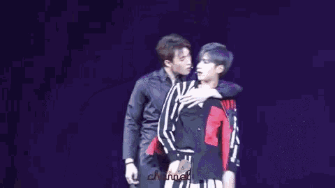 two men are standing next to each other on a stage .