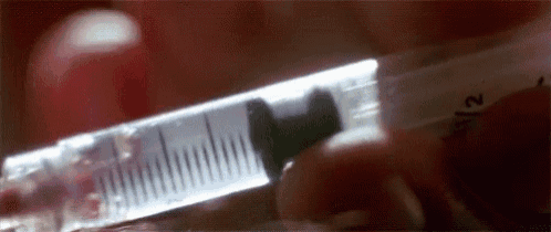 a close up of a person holding a syringe with a needle in it .
