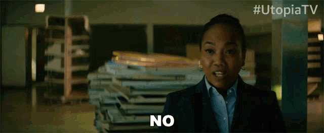 a woman says " no " in front of a pile of books