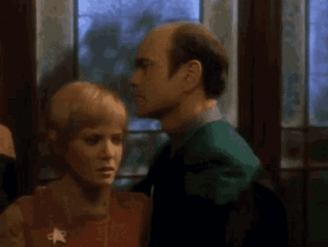 a man and a woman are hugging each other in a room .