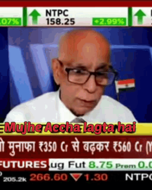 a man wearing glasses is on a television screen with a news headline in another language