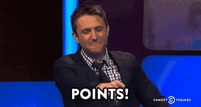 a man in a suit and tie is sitting in front of a blue background that says points