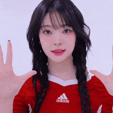 a woman wearing a red adidas sweater with braids