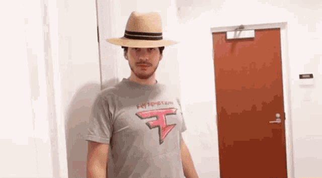 a man wearing a hat and a t-shirt with the letter f on it .