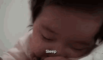 a close up of a baby 's face with the words `` sleep '' written on the bottom .