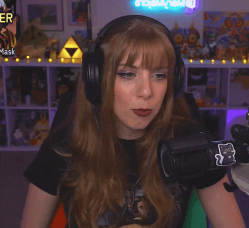 a woman wearing headphones is sitting in front of a microphone in front of a sign that says mask