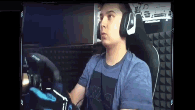 a man wearing headphones is sitting in a gaming chair .