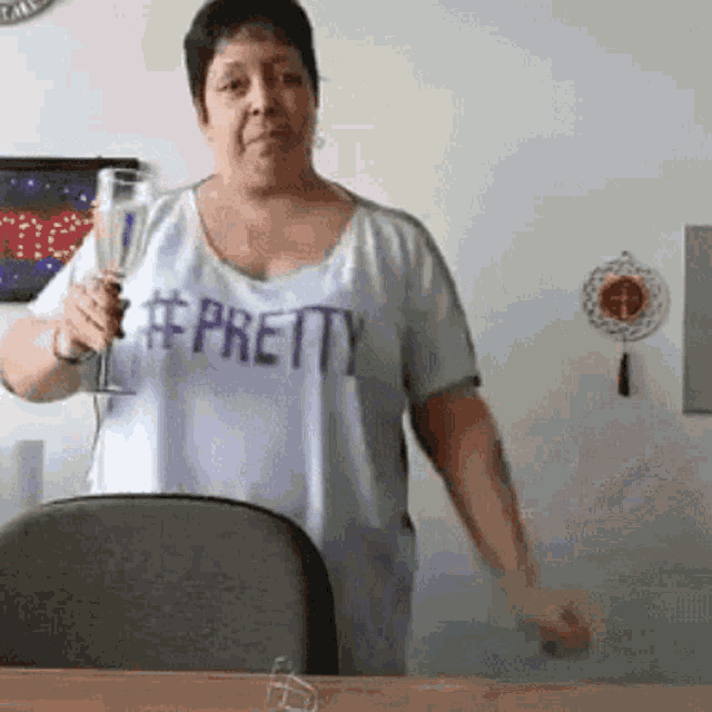 a woman wearing a #pretty shirt holds a glass of wine