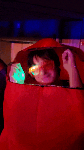 a man in a red inflatable costume is dancing