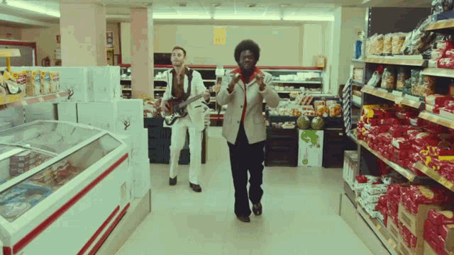 two men playing guitars in a grocery store aisle