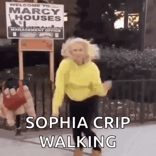 a woman in a yellow sweater is walking in front of a marcy houses sign .