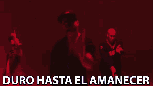 three men are dancing in a video with the words duro hasta el amanecer
