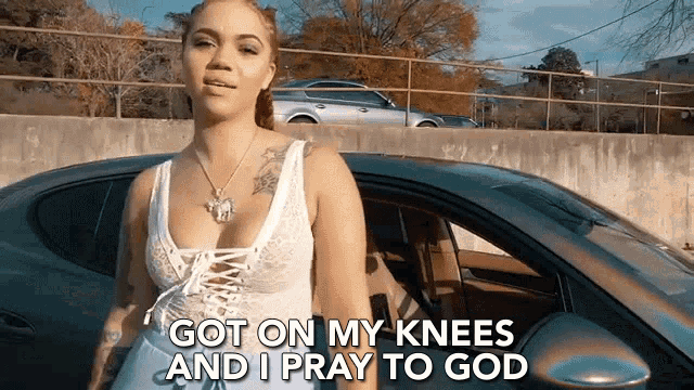 a woman is standing in front of a car with the words `` got on my knees and i pray to god ''