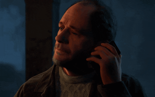 a man with a beard is talking on a cellphone