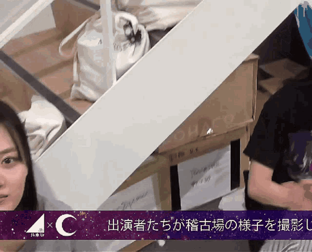 a woman is standing in front of a stack of boxes with the number 4c on the bottom