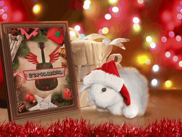 a white rabbit wearing a santa hat is standing next to a framed picture of a guitar