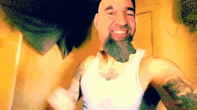 a man with a beard and tattoos is smiling