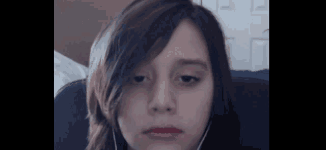 a young girl wearing earphones looks at the camera