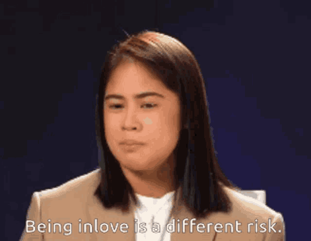a woman in a suit is saying being in love is a different risk