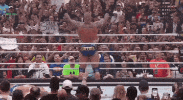 a man in a wrestling ring with a sign that says shawe
