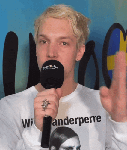 a man holding a microphone that says eurovision