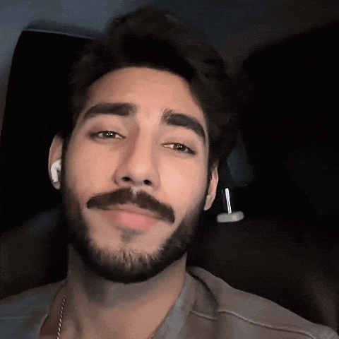 a man with a beard is wearing ear buds