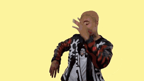 a man is covering his face with his hand while dancing .