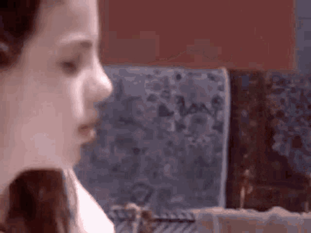 a close up of a woman 's face with a couch in the background