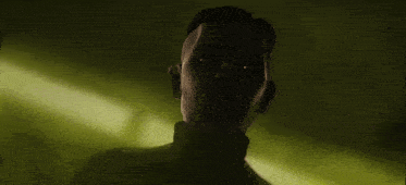 a close up of a man 's face in the dark with glowing eyes