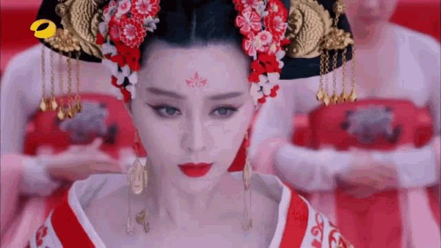 a woman in a traditional costume with flowers in her hair and red lipstick .