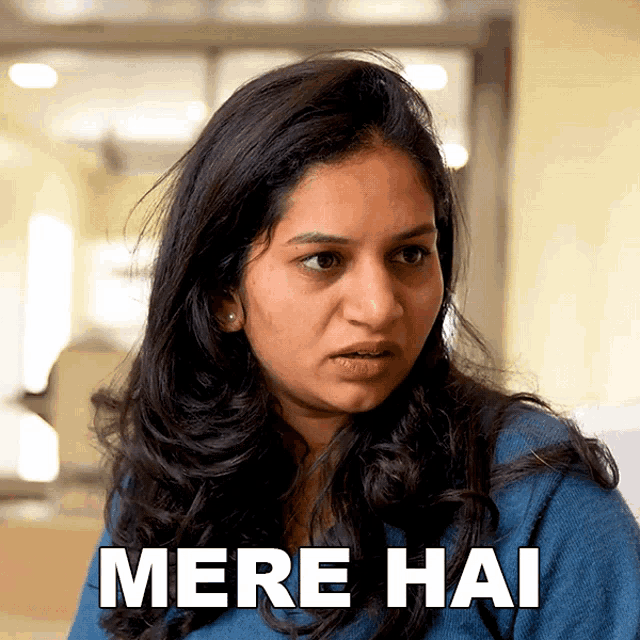 a woman in a blue shirt with the words mere hai on her face