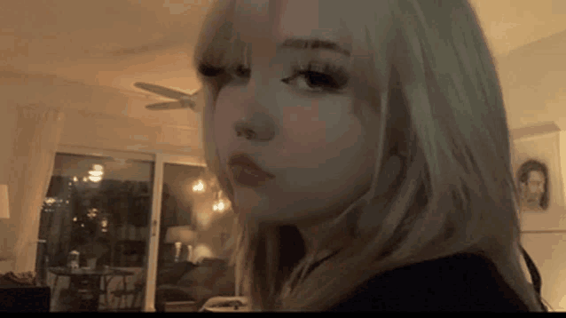 a girl with blonde hair is looking at the camera
