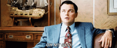 a man in a suit and tie is sitting in a chair and says oh my god .