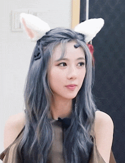 a woman with gray hair and white bunny ears on her head .