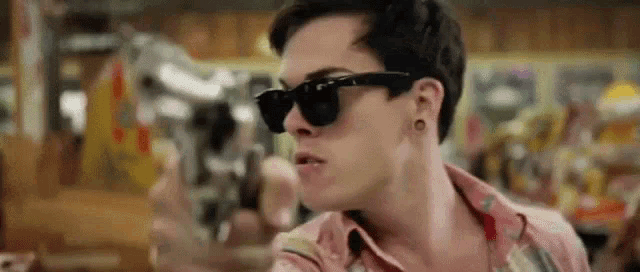 a man wearing sunglasses is sitting at a table in a restaurant .