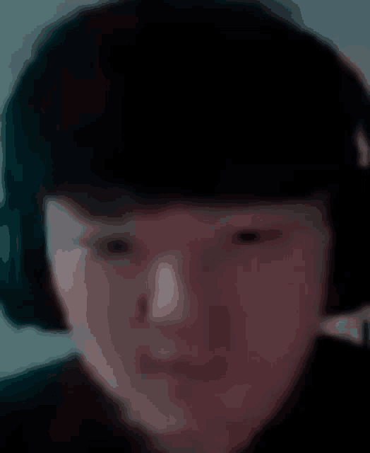 a close up of a person wearing headphones and looking at the camera .